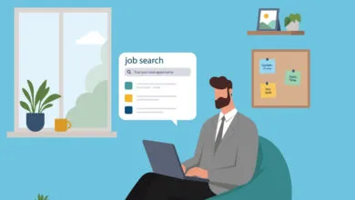 Vector illustration of a bearded man in a suit searching for jobs on his laptop at home.