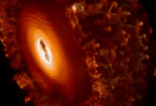 Swirling orange and white liquid abstractly resembles a glowing celestial sphere or cosmic nebula.
