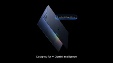 Sleek dark laptop angled against a black background with a glowing Gemini AI prompt bubble.