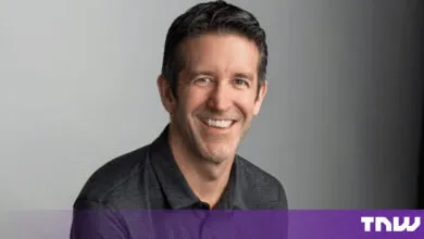 John Ternus, Apple's Senior Vice President of Hardware Engineering, smiling against a neutral gray background