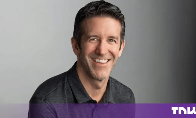 John Ternus, Apple's Senior Vice President of Hardware Engineering, smiling against a neutral gray background