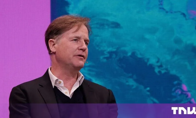 Nick Clegg speaking on stage in front of a blue and pink digital background
