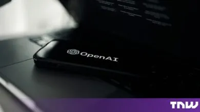 Smartphone displaying the OpenAI logo resting on a laptop keyboard