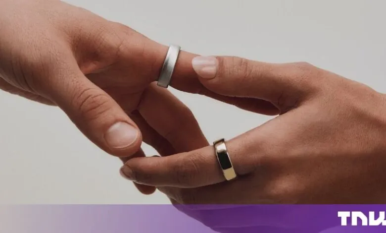Two hands gently reach toward each other, both wearing minimalist silver and gold smart rings.