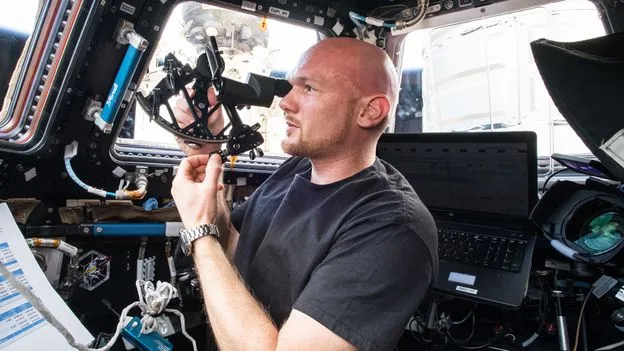 Astronaut Alexander Gerst uses a celestial navigation sextant inside the International Space Station.