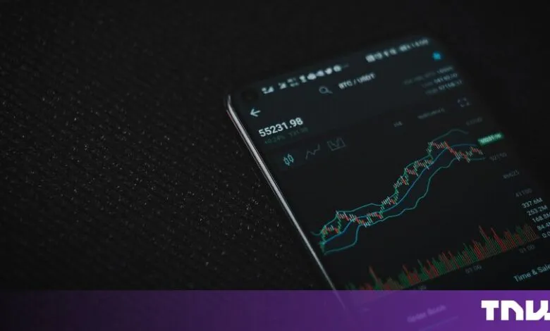 Smartphone displaying a cryptocurrency trading chart with market data against a dark background