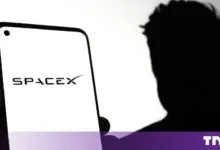 Smartphone displaying the SpaceX logo with a silhouetted figure of Elon Musk in the background.