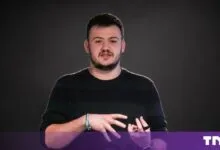 Stefan Gergely of Veridion gesturing while speaking on stage against a dark background