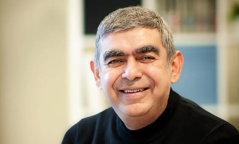 Close-up portrait of businessman and technologist Vishal Sikka smiling in a black turtleneck.