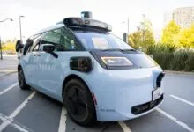 Light blue Waymo autonomous vehicle parked on a city street