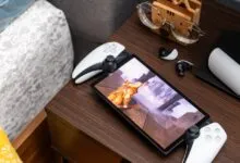 PlayStation Portal handheld device displaying a video game on a dark wooden nightstand.