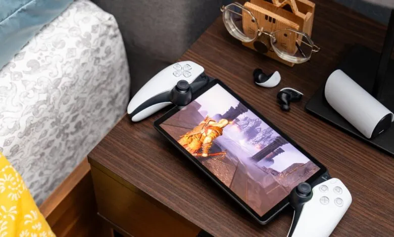 PlayStation Portal handheld device displaying a video game on a dark wooden nightstand.