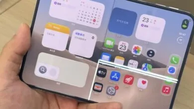 Close-up of a foldable smartphone running a custom iOS-style interface on both screens.