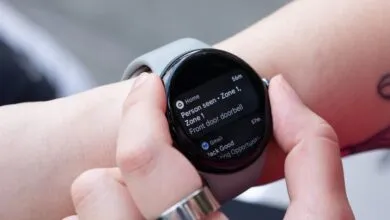 Close-up of a person wearing a Google Pixel Watch 3 displaying a smart home notification.