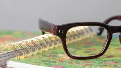 Close-up of smart glasses resting on a colorful spiral notebook.