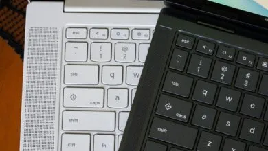 Close-up of a black laptop keyboard resting on top of a white laptop keyboard.