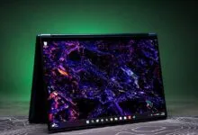 Lenovo Yoga laptop displayed in tent mode with a vibrant purple and blue abstract wallpaper.