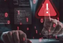 Businessman touching a digital red warning sign surrounded by code and binary numbers