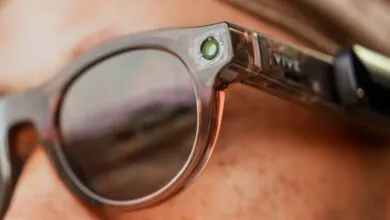 Close-up of HTC VIVE smart glasses featuring a prominent built-in camera lens on the frame.