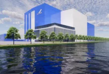 Architectural rendering of the large Blue Origin upper stage facility beside a calm body of water.