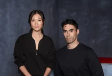 Portrait of a woman and man wearing black casual attire against a dark textured background
