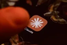 Close-up of a finger tapping the Claude AI app icon on a dark screen.