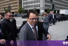 Anthropic CEO Dario Amodei walks down a Washington D.C. street surrounded by security and press.