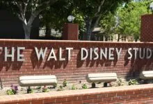 The iconic brick entrance sign reading 'THE WALT DISNEY STUDIOS' in silver lettering.