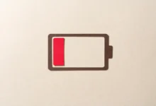 Papercraft low battery icon with a red indicator on a textured beige background