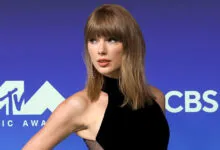 Taylor Swift posing on the red carpet at the MTV Video Music Awards in a black dress.
