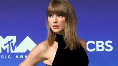Taylor Swift posing on the red carpet at the MTV Video Music Awards in a black dress.