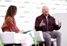 A man gesturing while speaking on stage during a TechCrunch Disrupt panel discussion.
