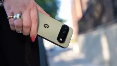 Close-up of a person holding a light green Google Pixel smartphone outdoors.