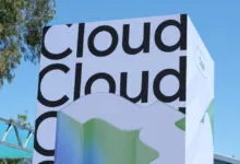 Large white pillar with black typography reading 'Cloud' repeatedly against a clear blue sky.