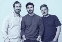 Justin, Hitesh, and Chris posing together against a plain light blue background.