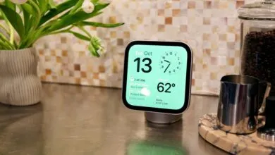 A smart display on a kitchen counter displaying date, time, weather, and schedule.
