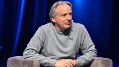 Software engineer Linus Torvalds wearing a gray Puma sweatshirt while speaking on stage.