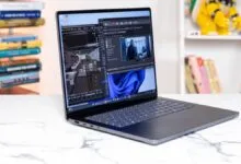 Modern dark gray Surface Laptop displaying complex 3D modeling software on a white marble desk.