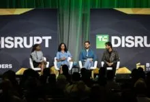 Four panelists seated in white armchairs on a stage at the TechCrunch Disrupt conference.