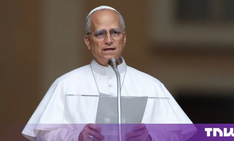 Pope Leo speaking at a podium with glasses and traditional white papal attire.