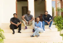 Four members of the Satlyt team pose together on white outdoor stairs outside a building.