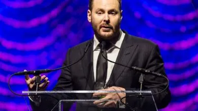 Entrepreneur Sean Parker speaks at a podium against a vibrant blue and purple background.
