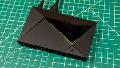 Black angular streaming device with connected cables resting on a green cutting mat.