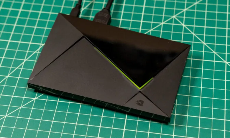 Black angular streaming device with connected cables resting on a green cutting mat.