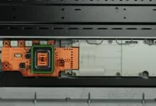 Close-up of an electric vehicle electrical box featuring orange and white components inside a black housing.