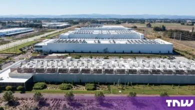 Aerial view of a massive modern data center complex with white industrial buildings and cooling units.