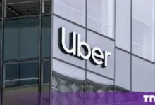 The Uber logo mounted on the glass facade of a modern corporate building