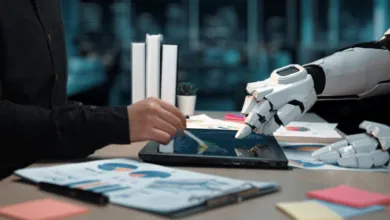 A human hand and a robotic hand working together on a digital tablet with financial charts.