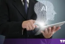 A businessman in a suit uses a tablet with a glowing AI brain circuit graphic floating above it.