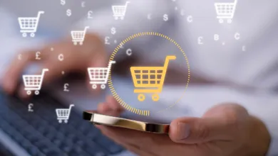 Person holding a smartphone with floating digital shopping cart and currency icons